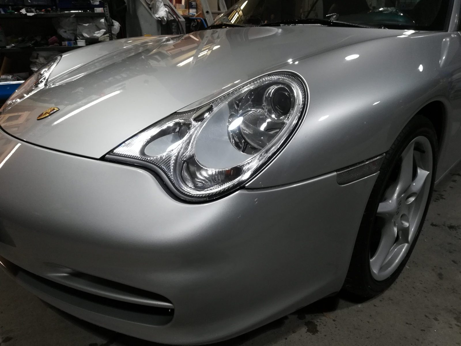 Il frontale di una Porsche 911 argento dopo la riverniciatura