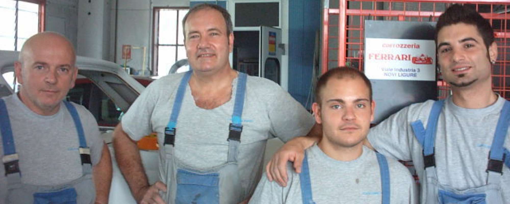 Il team della Carrozzeria Ferrari in officina, davanti all'insegna